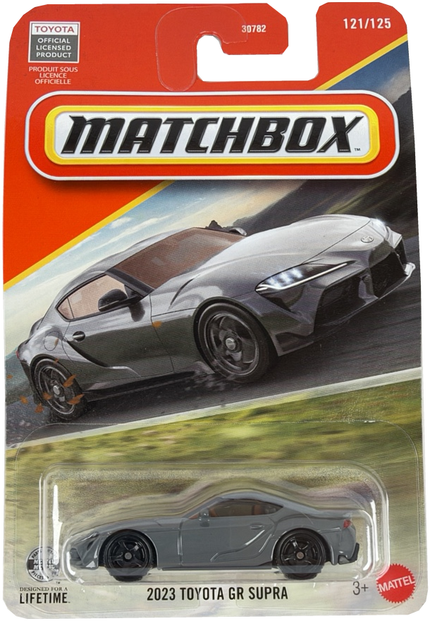 Matchbox diecast toy car of the 2023 Toyota GR Supra, featuring a gray car in a clear blister pack on a orange and yellow Matchbox card.