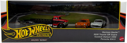 Hot Wheels Premimum Track Day Diorama display, a black, white, and red cardboard display showing 4 vehicles on a race track background.