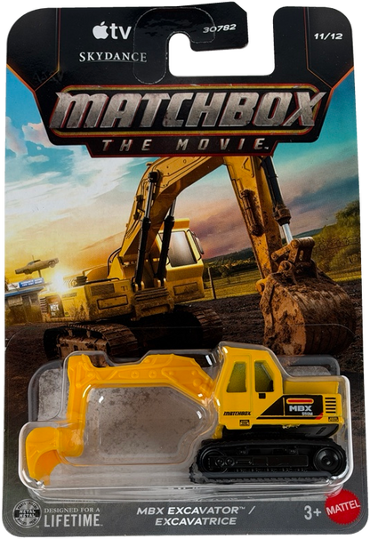 Matchbox The Movie MBX Excavator toy in its original blister card packaging, featuring a yellow and black excavator with a construction site background on the card.