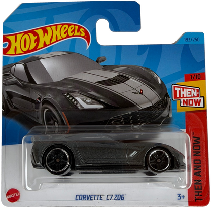 Hot Wheels Mattel then and now Corvette C7 206 diecast toy car in its original blister card packaging, featuring a dark gray car with white racing stripes.